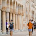 Students walking through the Great Court at UQ St Lucia, which is surrounded by sandstone buildings